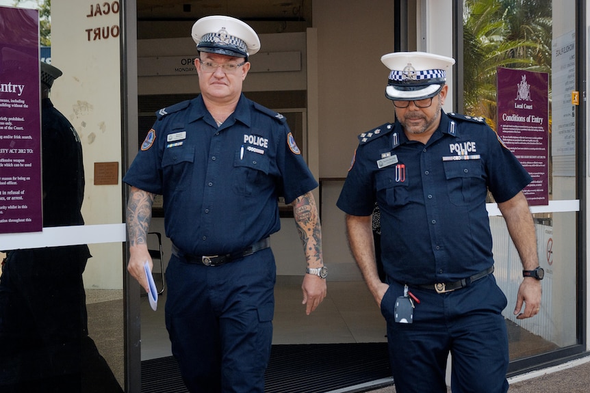 two male police officers in uniform exiting court