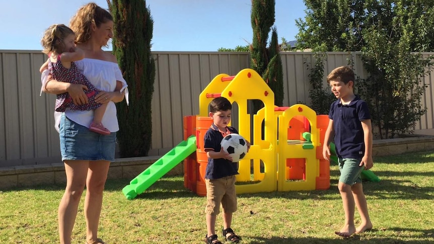 Tina Dorian with her three children in the backyard playing