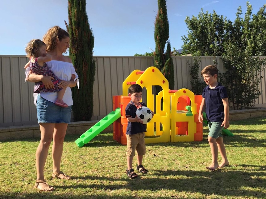 Tina Dorian with her three children in the backyard playing