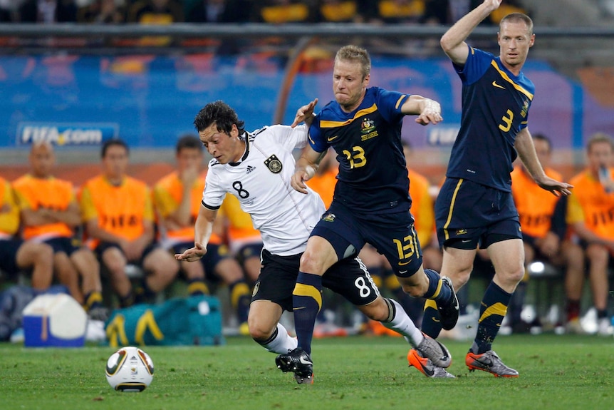 Mesut Ozil battles for the ball against the Socceroos