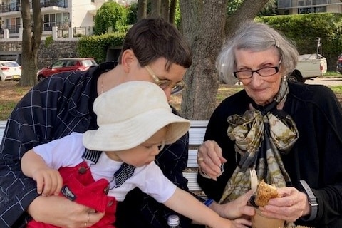 Wendy Smith wearing glasses and a scarf with her daughter and grandson