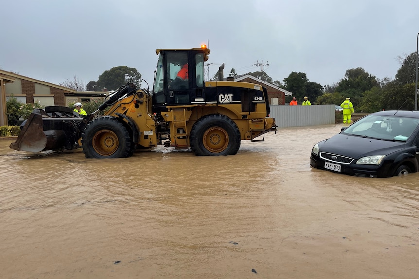A car next to a tractor in floodwaters