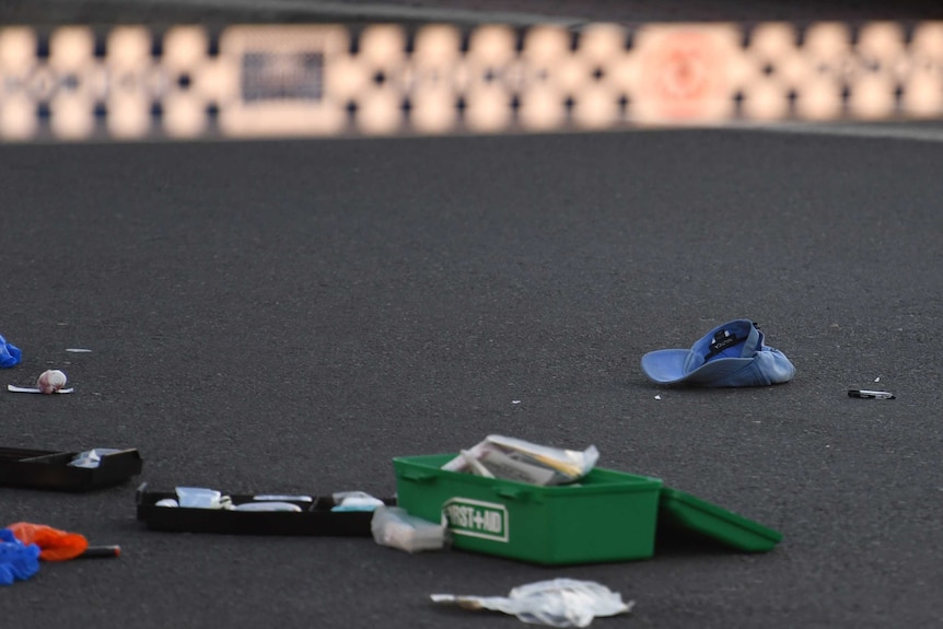 Medical equipment and a baseball cap on the ground.