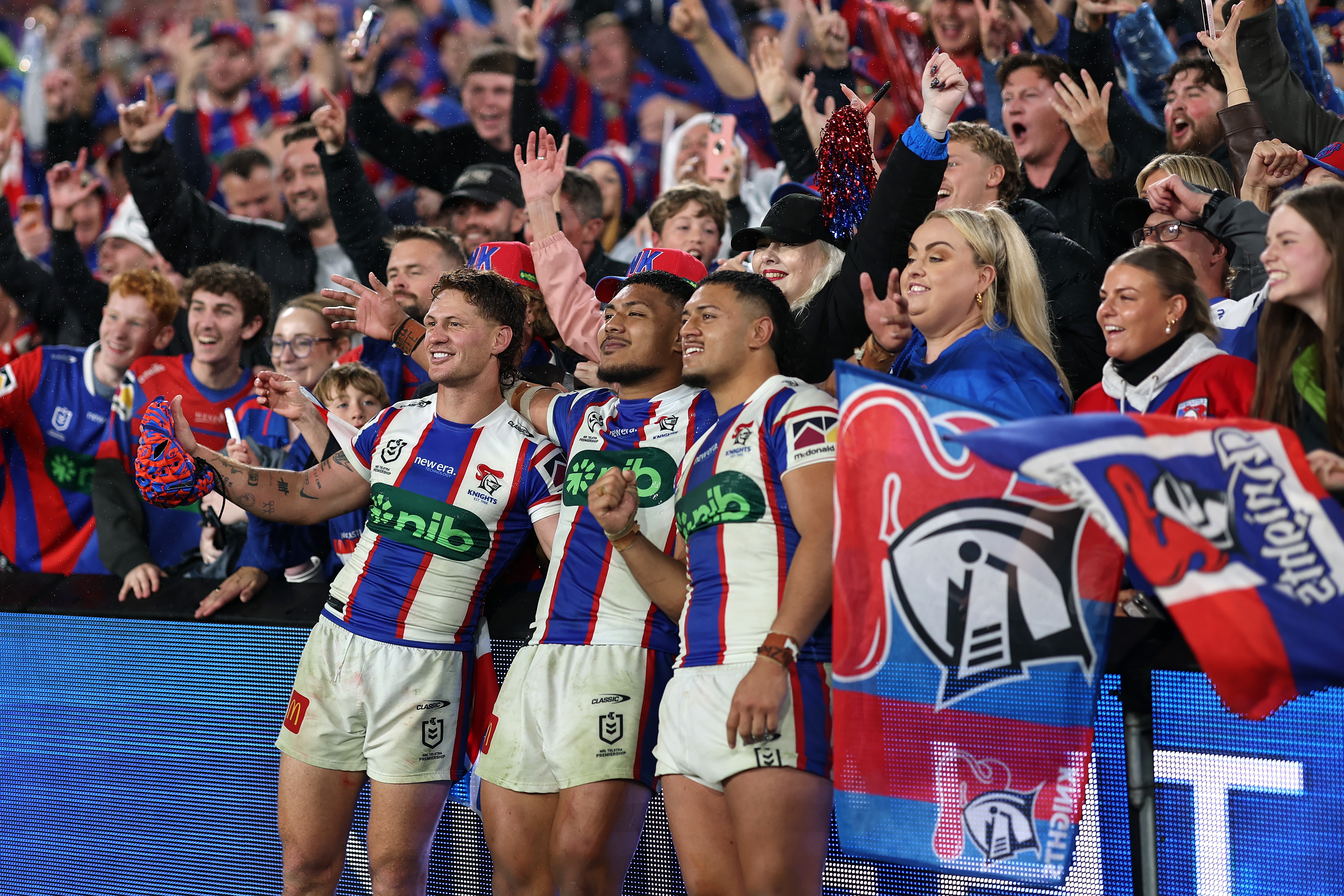 Three NRL players celebrate winning an NRL final 