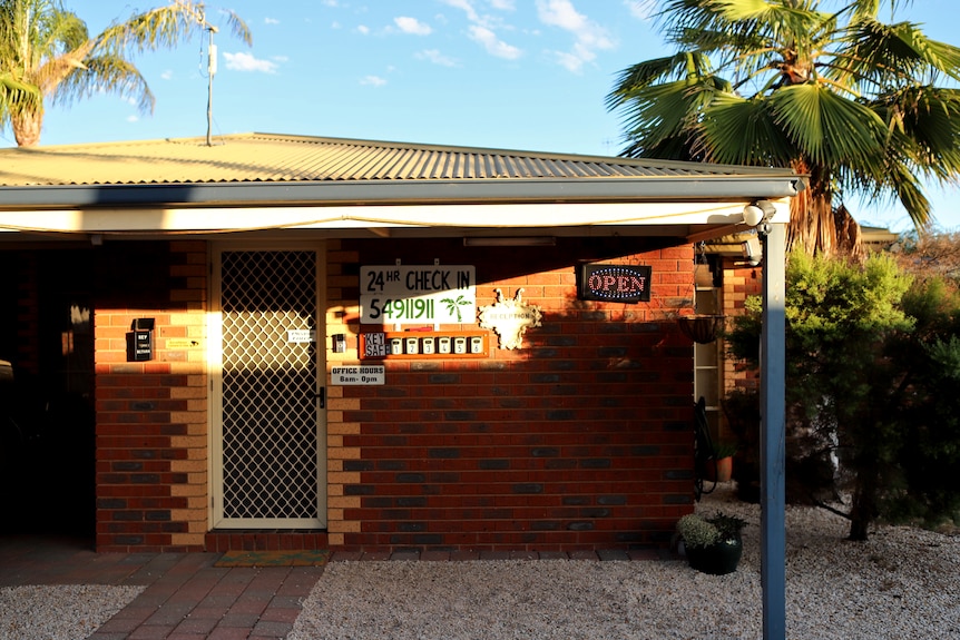 A Motel front entrance with an open sign and a door to reception 