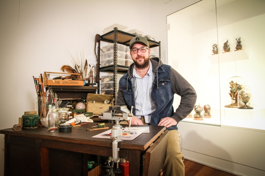 Saxon sits at a desk he owned as a child. 