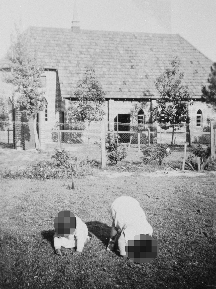 A black and white picture of two children playing outside the Chapel of St Michael and All Angels, Parkerville Children's Home.