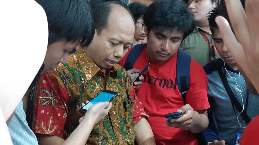 Nugroho surrounded by journalists following the Palu earthquake.