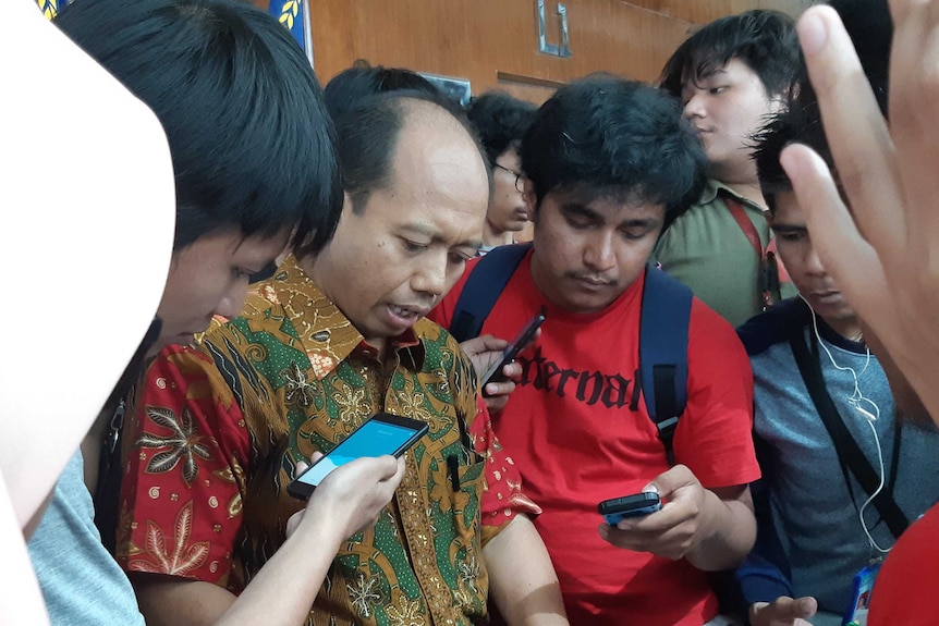 Nugroho surrounded by journalists following the Palu earthquake.