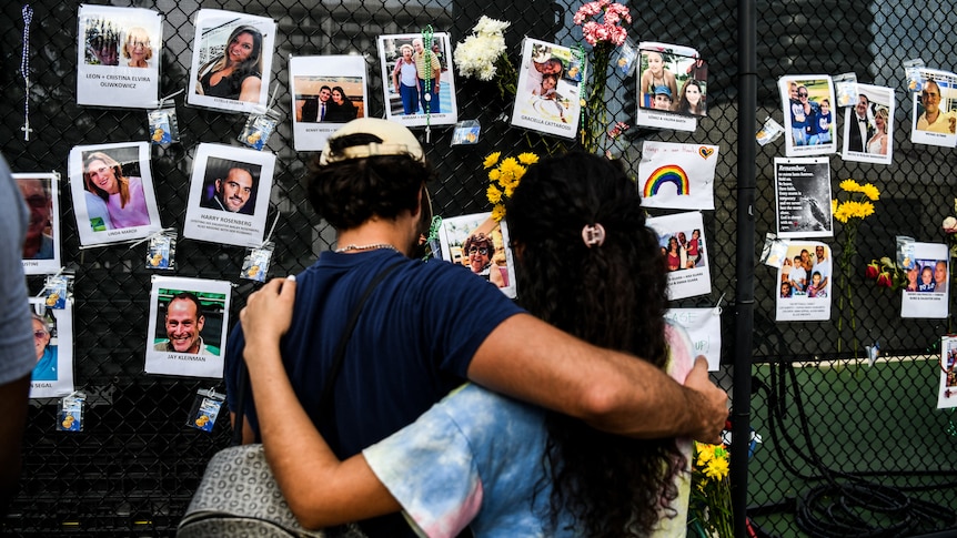 People visit the makeshift memorial for the victims of the building collapse