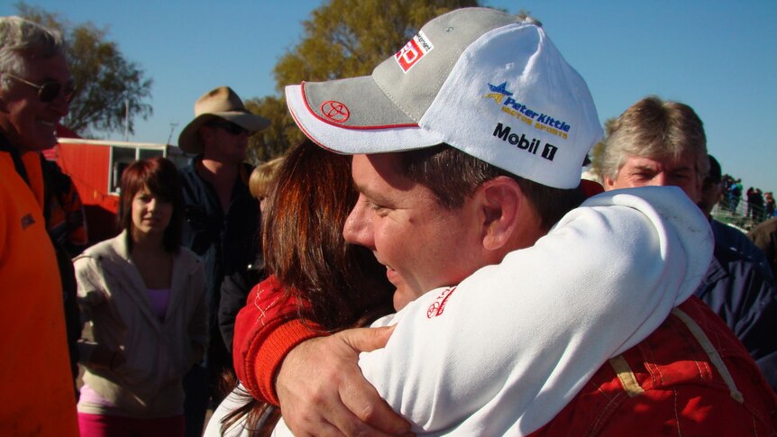 Finke winner, Dave Fellows receives a hug from the crowd.