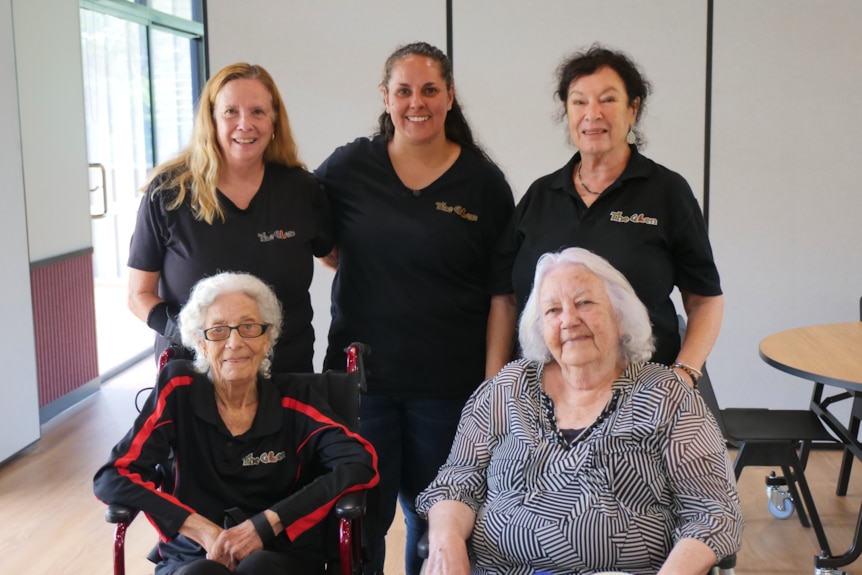 A group of five women smile at the camera