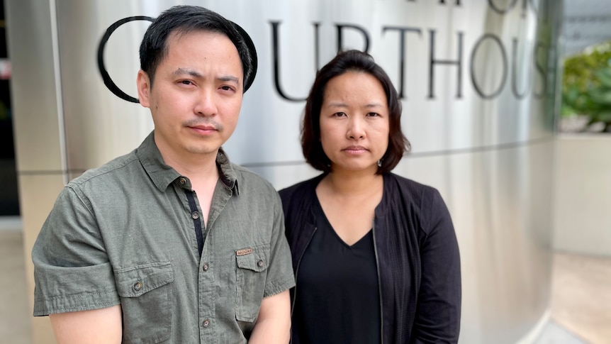 a thai couple standing outside the southport court house