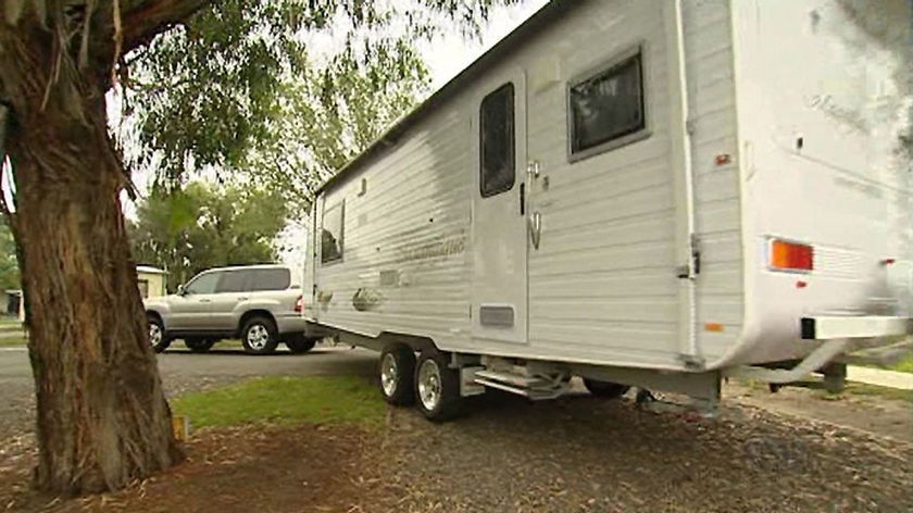 A 4WD towing a caravan at a caravan park.