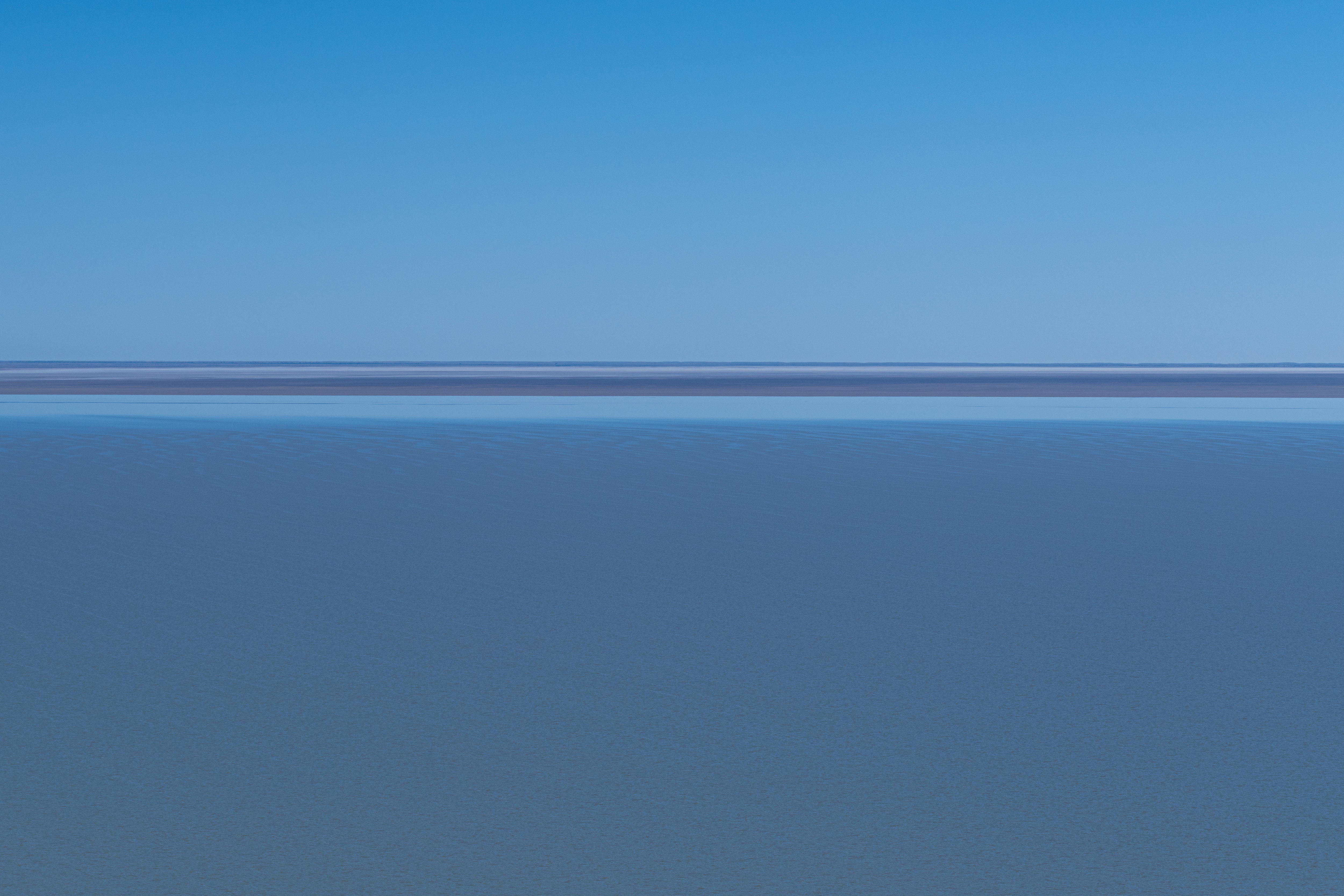 Aerial looking across at a horizon, with blue water taking up most of the screen