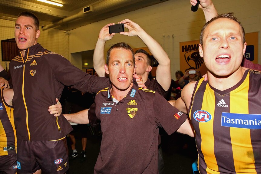 Coach Alastair Clarkson celebrates with Hawthorn's Max Bailey and Brad Sewell