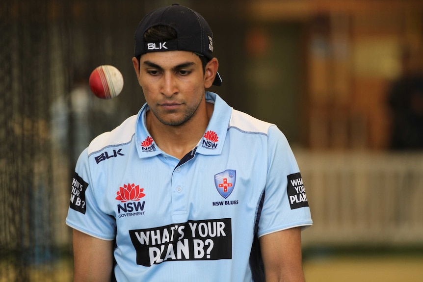 Jason Sangha throwing a cricket ball in the air at a New South Wales training session.