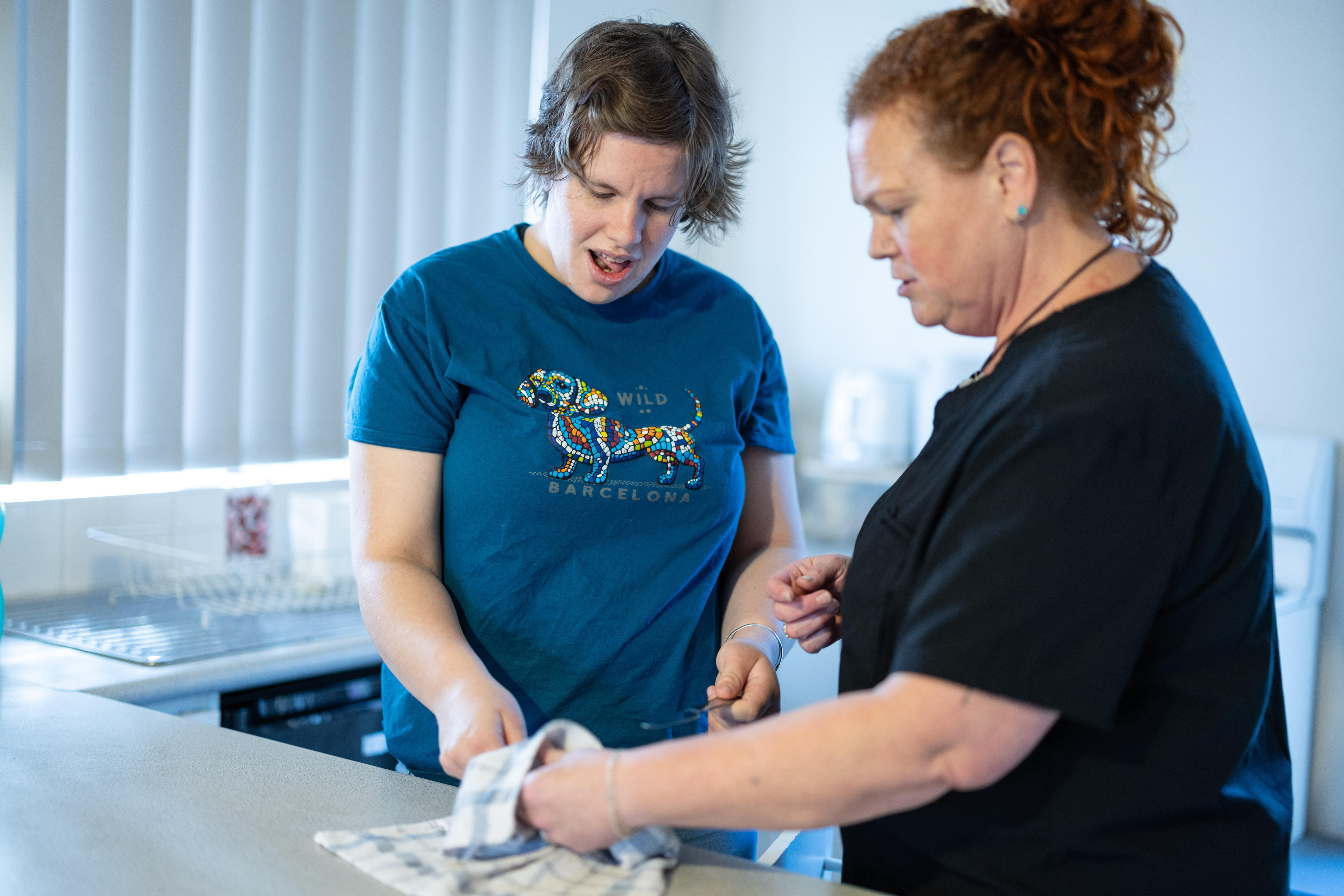 A young adult woman helping wipe down a kitchen counter