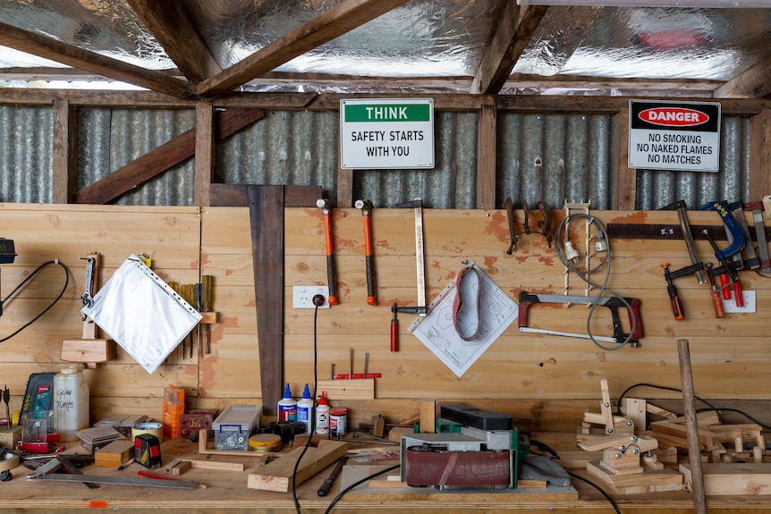 Tools laid out on a bench in a shed.