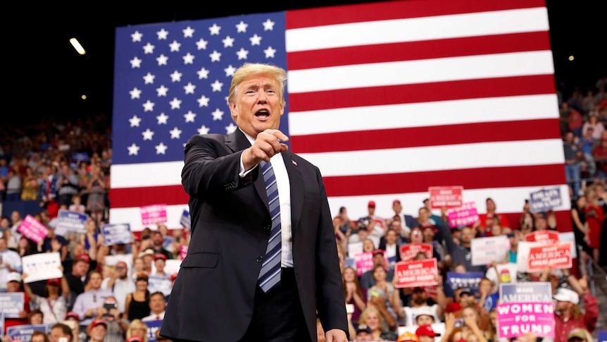 Trump greets the crowd as he arrives at a campaign rally.