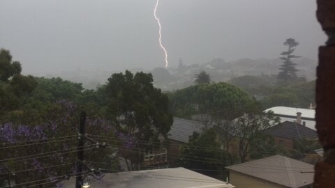 Lightning strikes an unseen target as skies in Sydney are an ominous grey during unprecedented storms.