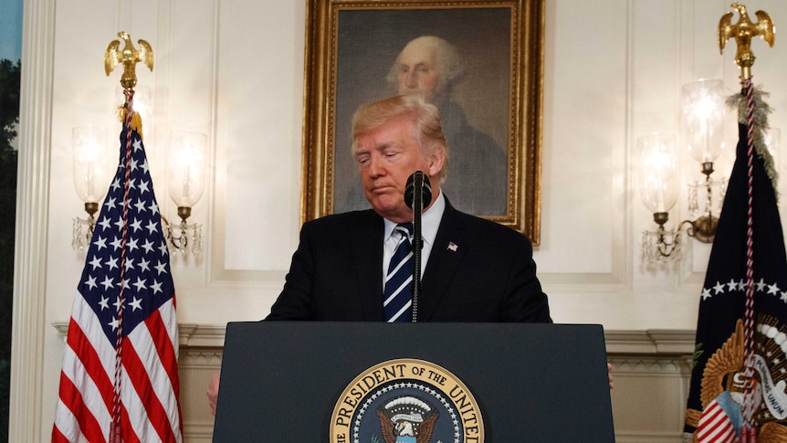 Donald Trump looks sad as he prepares to leave the white house podium.