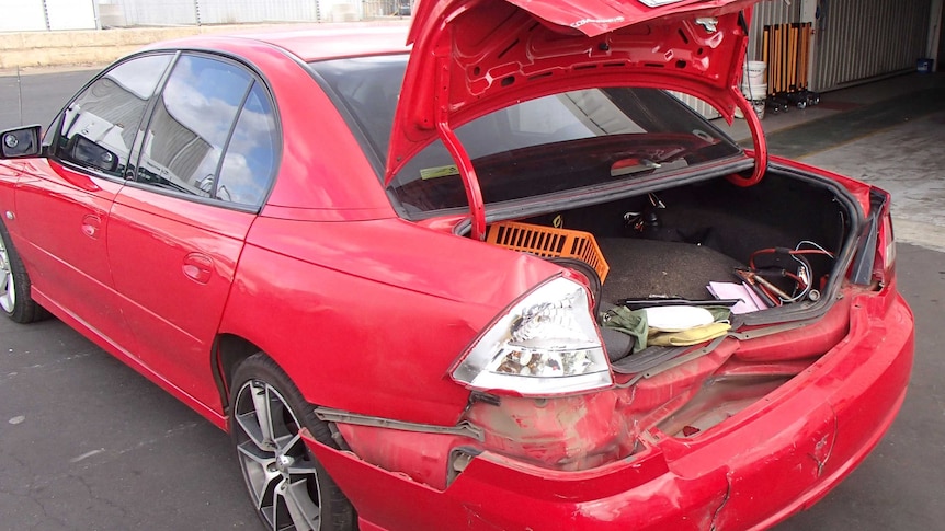 Red Holden Commodore with boot up and damage to back bumper bar