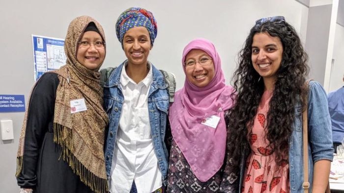 Four women from different backgrounds standing together