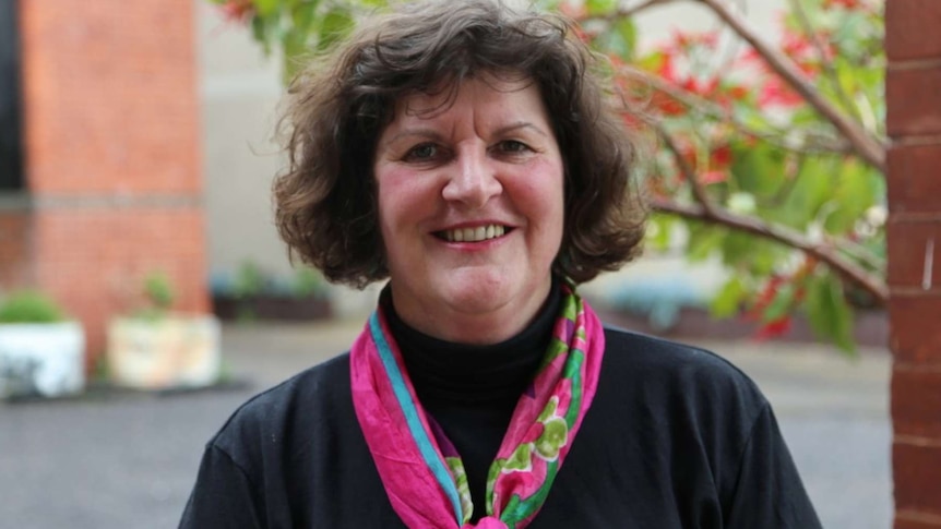 A lady smiling with a bright scarf on.