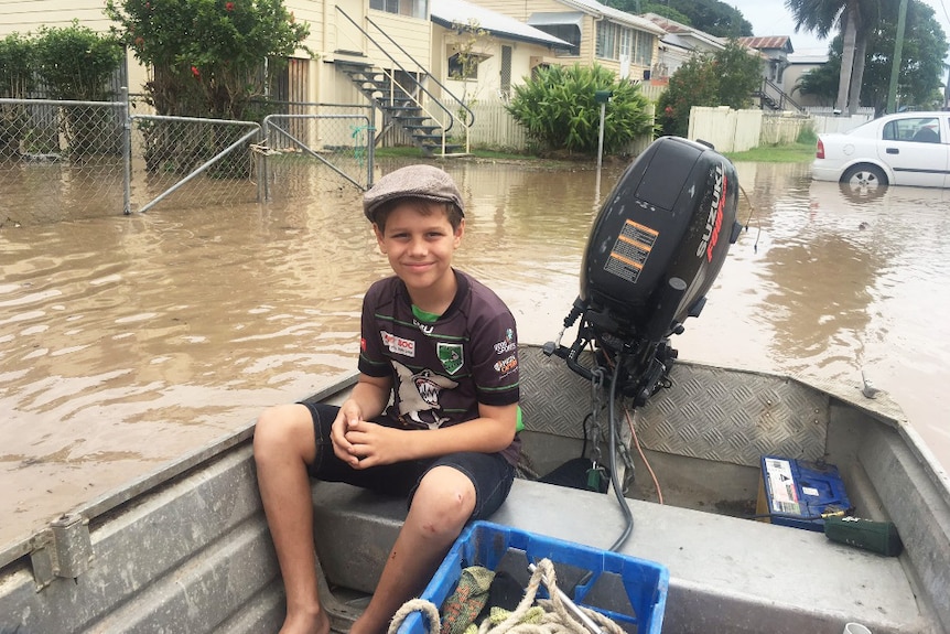Ten-year-old Rockhampton resident Angus Groves, sits in a boat in a street on April 6, 2017