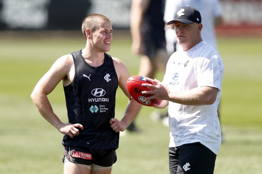 Michael Voss speaks to Matthew Owies at a Carlton training session