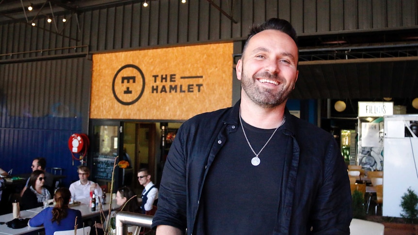 A smiling man stands outside the Hamlet food court in Braddon.