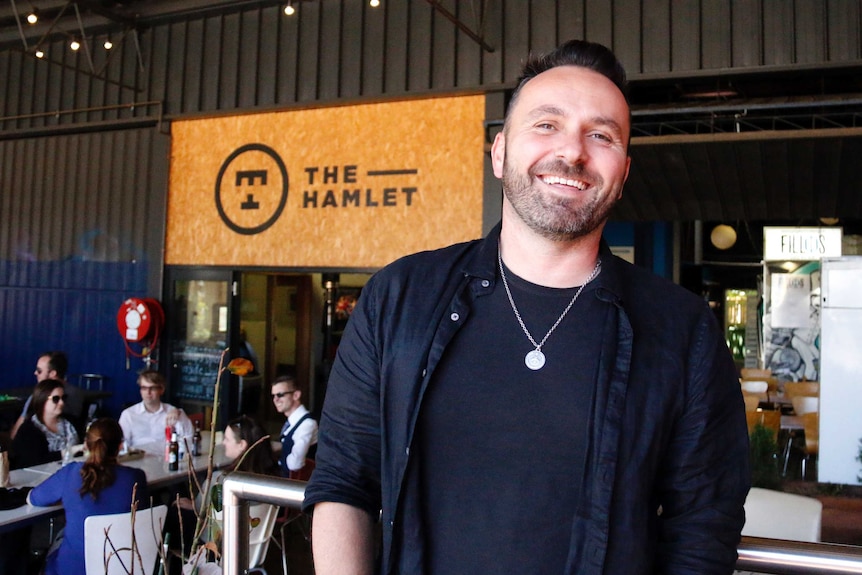 A smiling man stands outside the Hamlet food court in Braddon.