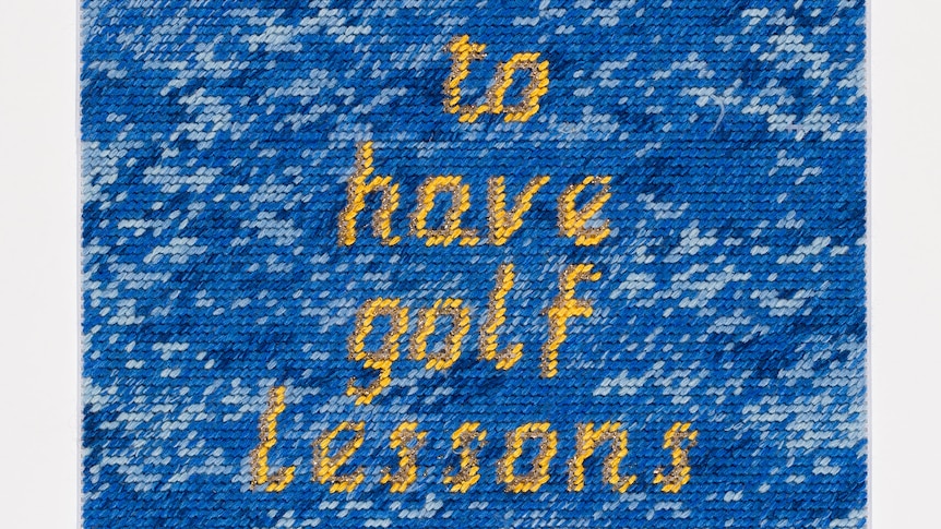 A blue tapestry sign with yellow letter saying 'she was able to have golf lessons'