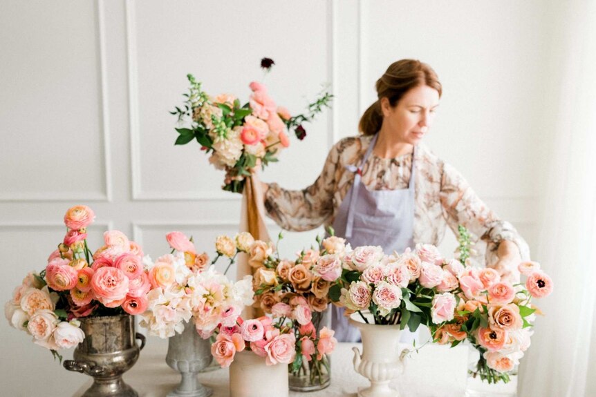 McKinlay florist Belinda Murphy arranging bunches of pink roses.