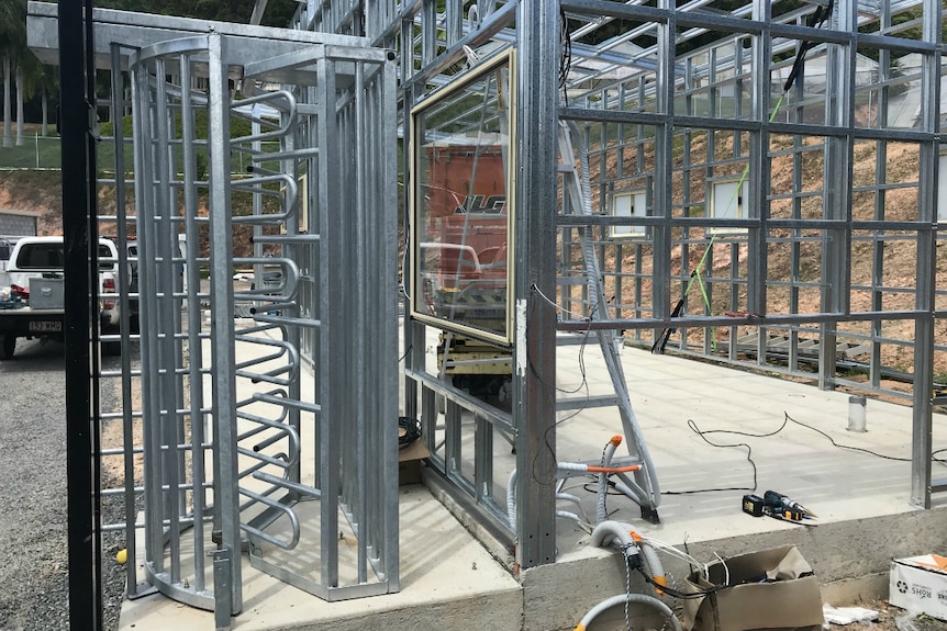 A steel turnstile next to an incomplete steel building.