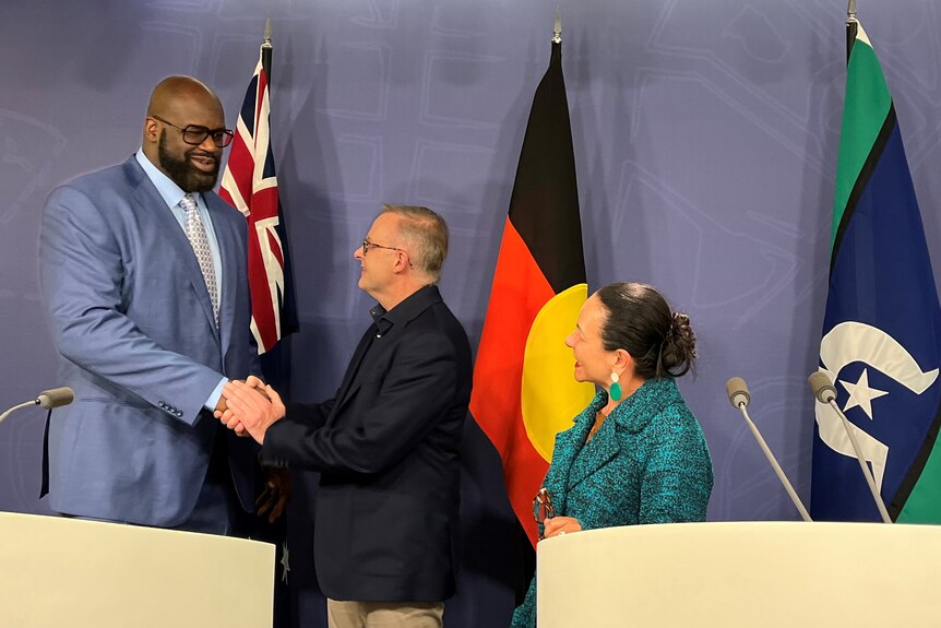 Shaquille O'Neal shakes Anthony Albanese's hand at a press conference as Linda Burney looks and smiles