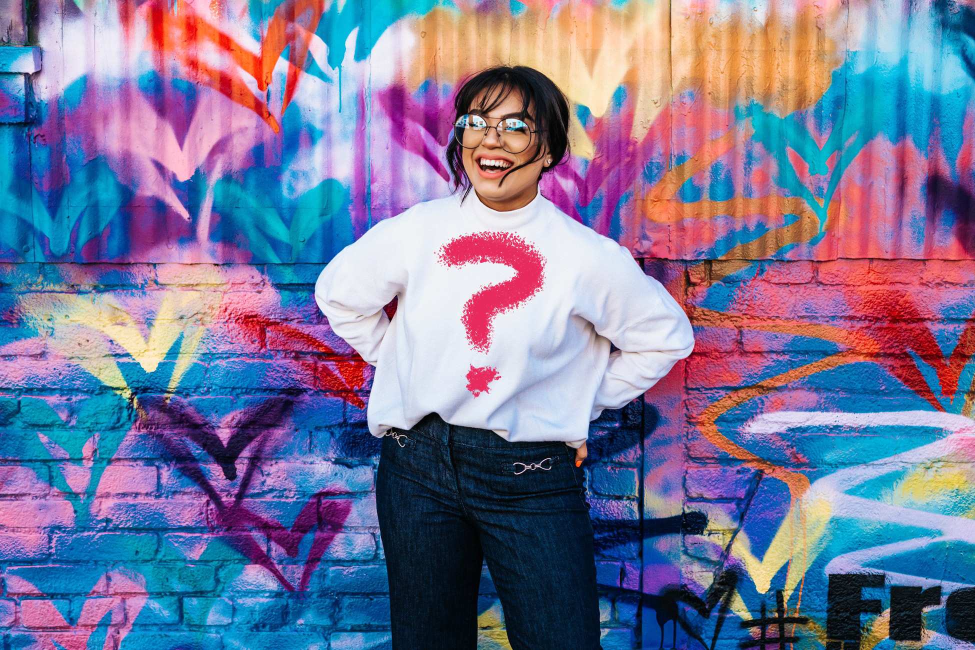 Fashionista standing against wall with question mark t-shirt, representing the search for a personal style/fashion aesthetic