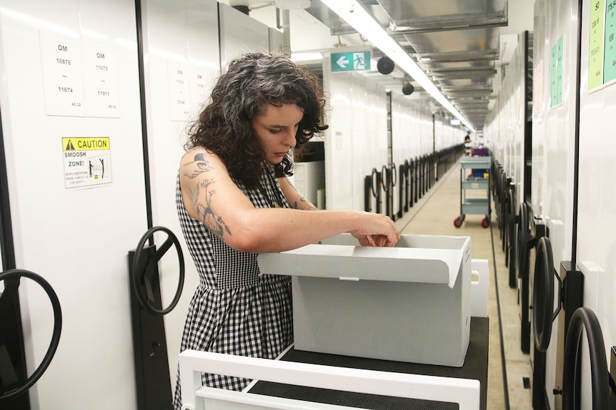 State Library of Queensland program officer Chenoa Pettrup working in the climate-controlled storage area in Brisbane.