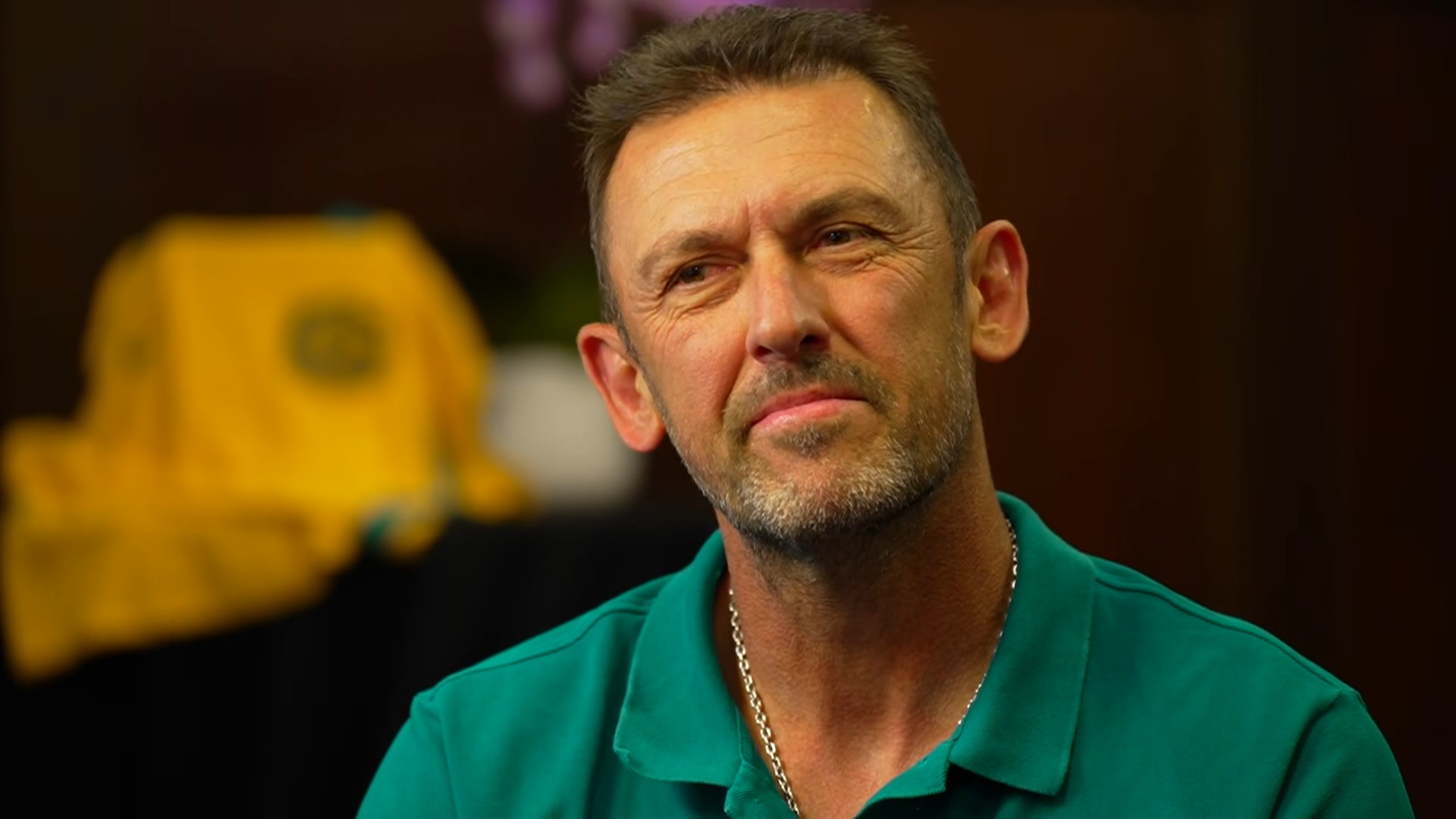 A middle aged man with short brown hair listening to a question in a sit-down interview