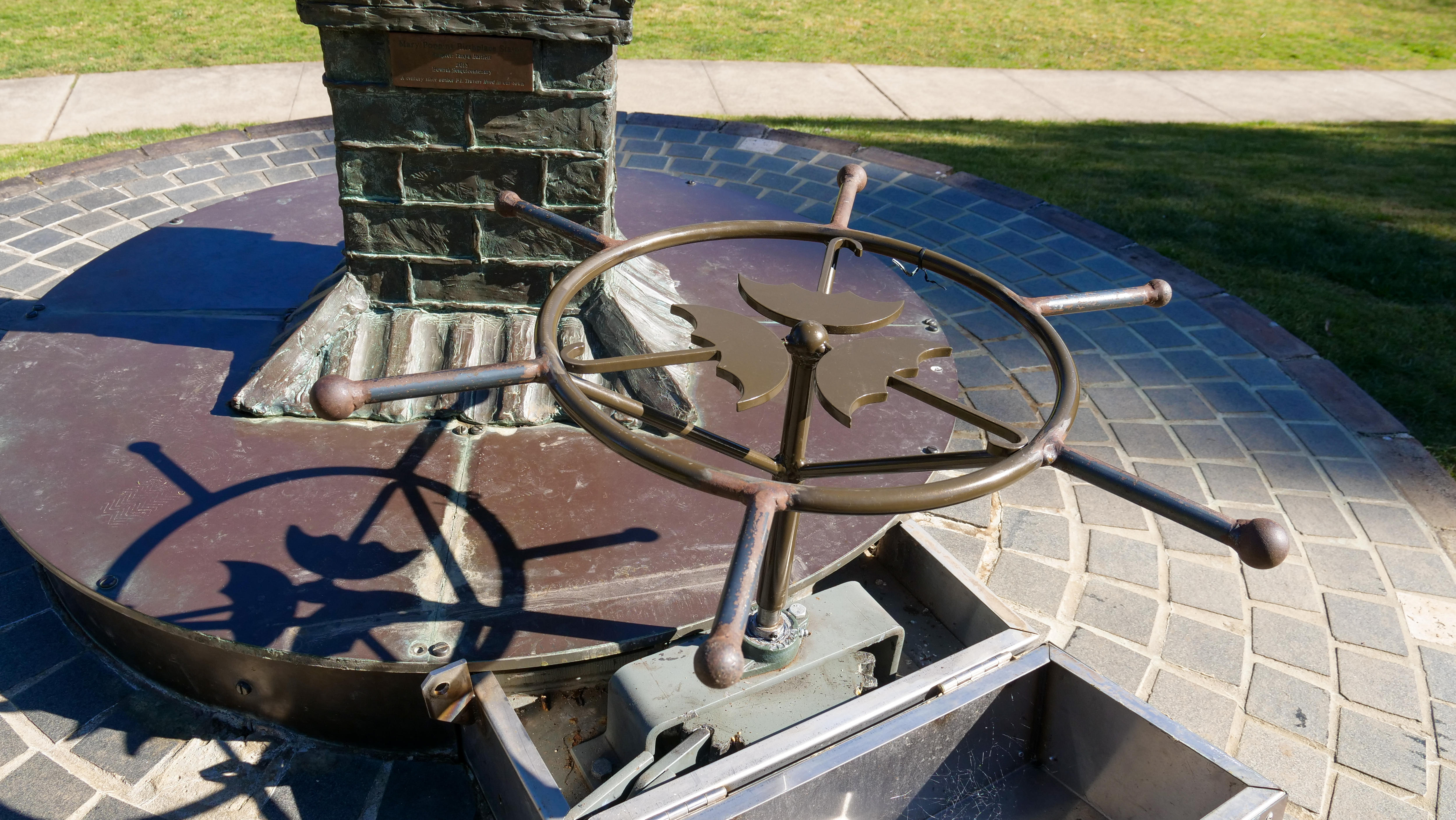 A bronze turntable wheel depicting Mary Poppins umbrellas.