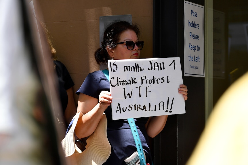 A woman holds a placard