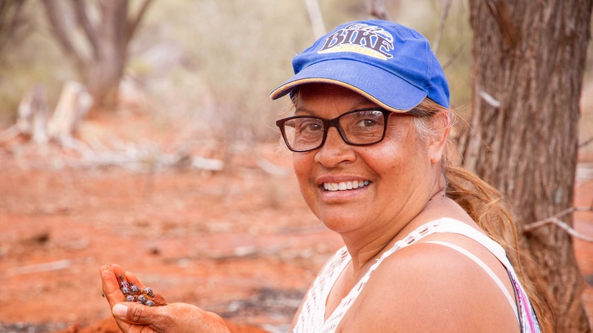 Edie Ulrich holding a hand full of honey ants, dug up from a spot the family like to visit near Kalgoorlie.