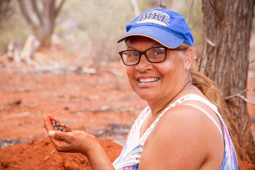 Edie Ulrich holding a hand full of honey ants, dug up from a spot the family like to visit near Kalgoorlie.