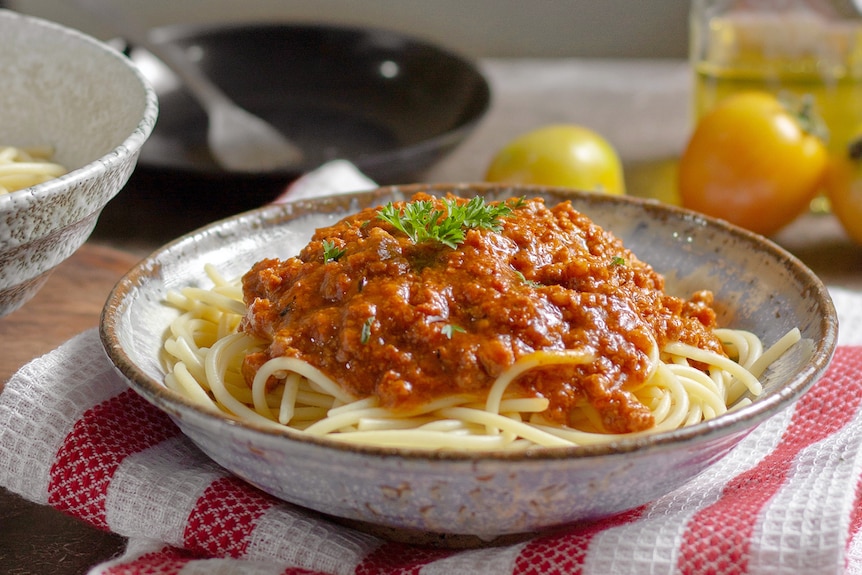 A tasty bowl of spaghetti bolognaise on a kitchen counter.