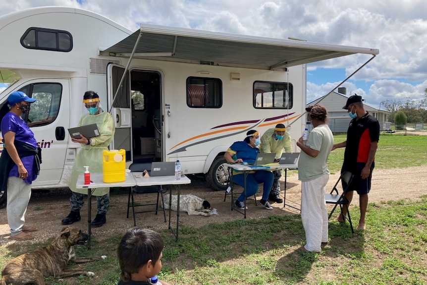 medical staff provide vaccinations to western residents out of a caravan