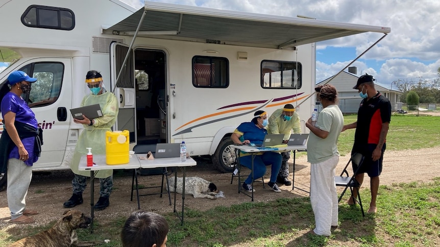 medical staff provide vaccinations to western residents out of a caravan