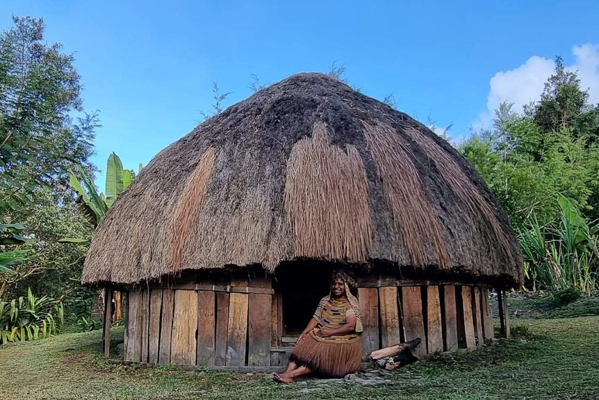 Rode Wanimbo sits in the doorway of a traditional hut called kunume in Lani, and bilamu in Walak.