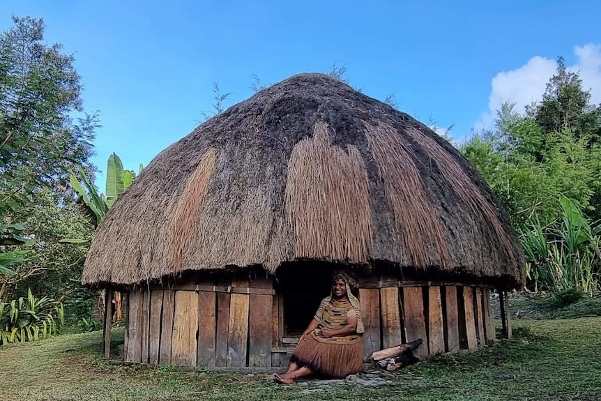Rode Wanimbo sits in the doorway of a traditional hut called kunume in Lani, and bilamu in Walak.