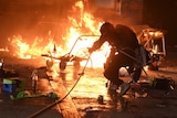 Student try to extinguish a fire at the entrance of Hong Kong Polytechnic University.